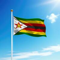 ondulación bandera de Zimbabue en asta de bandera con cielo antecedentes. foto