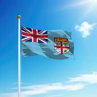 Waving flag of Fiji on flagpole with sky background. photo