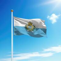 Waving flag of San Marino on flagpole with sky background. photo