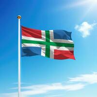 Waving flag of Groningen is a state of Netherlands on flagpole photo