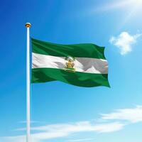 Waving flag of Andalusia is a community of Spain on flagpole photo