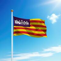 Waving flag of Balearic Islands is a community of Spain on flagpole photo