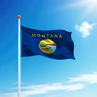 Waving flag of Montana is a state of United States on flagpole photo