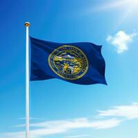 Waving flag of Nebraska is a state of United States on flagpole photo