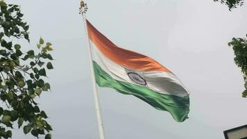 India flag flying high at Connaught Place with pride in blue sky, India flag fluttering, Indian Flag on Independence Day and Republic Day of India, tilt up shot, Waving Indian flag, Har Ghar Tiranga video