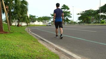 Jacarta, septiembre 23, 2023, aptitud masculino atleta corredor corriendo en el la carretera. Deportes personas líder un activo estilo de vida tren cardio en verano en ropa de deporte y Zapatos video