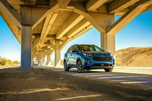 a blue kia sportage is parked under a bridge in t photo