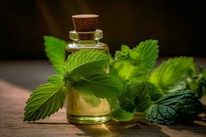 a bottle of essential oil next to a sprig of mint photo