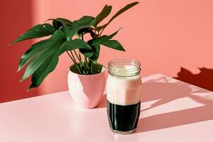 a bottle of milk with a black cap sits on a pink photo