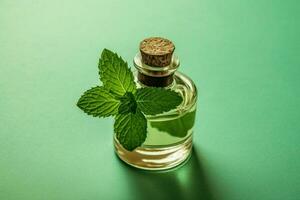 a bottle of mint essential oil with a green leaf photo