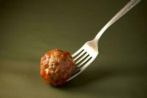 a fork with a bite of meatballs on it photo