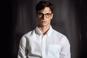 un hombre en un blanco camisa con lentes y un camisa t foto