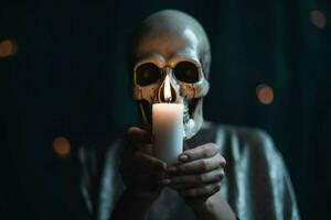 a person with a skull mask and a candle in their photo