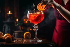 a woman is pouring a red cocktail into a glass wi photo