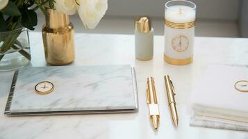 An organized workspace featuring stylish stationery items such as gold-accented pens and a planner with space for text, set against a subtly patterned marble background. AI generated. photo