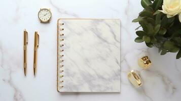 An organized workspace featuring stylish stationery items such as gold-accented pens and a planner with space for text, set against a subtly patterned marble background. AI generated. photo