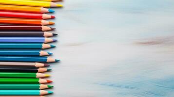 An overhead view of color pencils alongside other essential art supplies with space for text, like sketchbooks or brushes, creating a textured tableau of creativity. AI generated photo