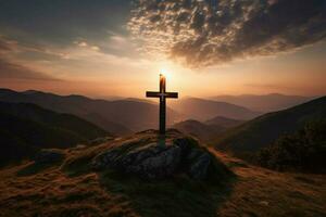 cross on a mountain with the sun setting behind it photo