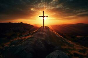 cross on a mountain with the sun setting behind it photo