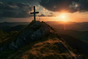 cross on a mountain with the sun setting behind it photo