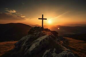 cross on a mountain with the sun setting behind i photo