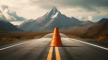 traffic cone on a winding road with mountains photo