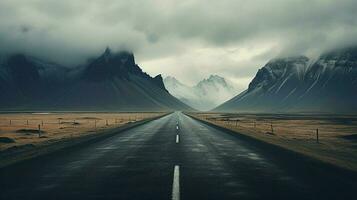 an empty road with mountains in the background photo