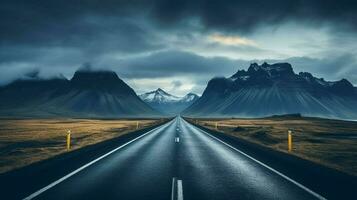 an empty road with mountains in the background photo