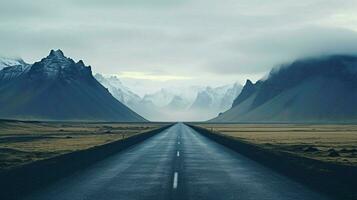 an empty road with mountains in the background photo
