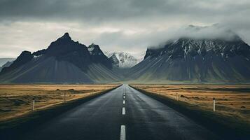 an empty road with mountains in the background photo