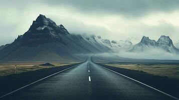 an empty road with mountains in the background photo