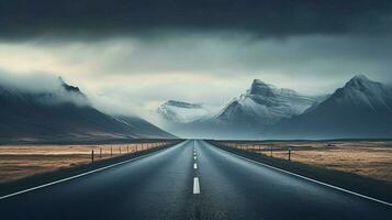 an empty road with mountains in the background photo