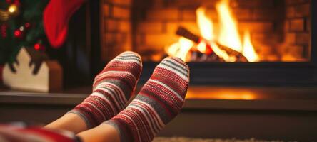 Feet in woollen socks by the Christmas fireplace in winter time photo