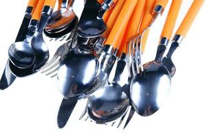 a white dish rack with orange and silver utensils photo