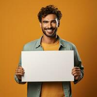 hermoso joven hombre participación un blanco sábana de papel foto