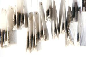 a pile of tea bags on a white surface photo