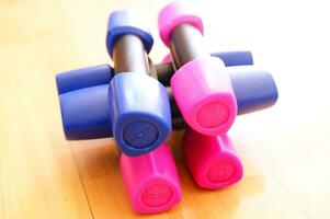 a pile of blue and pink plastic toys on a wooden floor photo