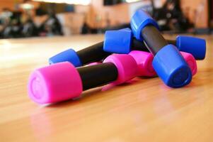 a pile of blue and pink plastic toys on a wooden floor photo