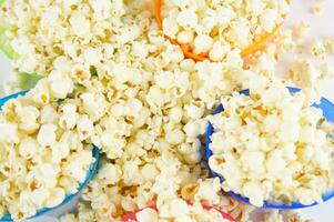 four colorful bowls of popcorn on a white surface photo