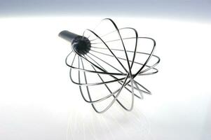 a black and silver whisk with a spiral shape photo