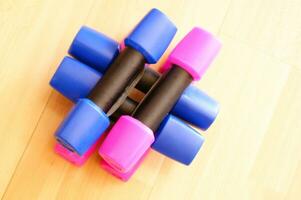 a pile of blue and pink plastic toys on a wooden floor photo