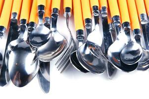 a white dish rack with orange and silver utensils photo