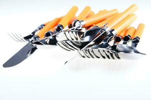 a white dish rack with orange and silver utensils photo