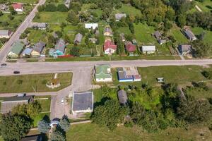 panoramic aerial view of eco village with wooden houses, gravel road, gardens and orchards photo