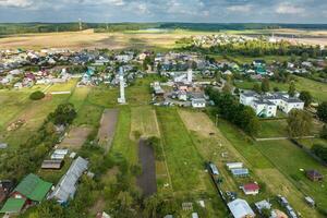 panoramic aerial view of small provincial town or big eco village with wooden houses, gravel road, gardens and orchards photo