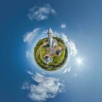 little planet transformation of spherical panorama 360 degrees overlooking church in center of globe in blue sky. Spherical abstract aerial view with curvature of space. photo