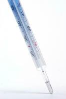 un termómetro es mostrado en un blanco antecedentes foto