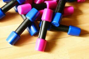 a pile of blue and pink plastic toys on a wooden floor photo