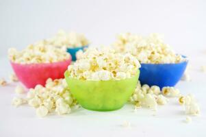 four colorful bowls of popcorn on a white surface photo