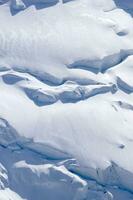 two people are hiking up a mountain with snow covered mountains photo